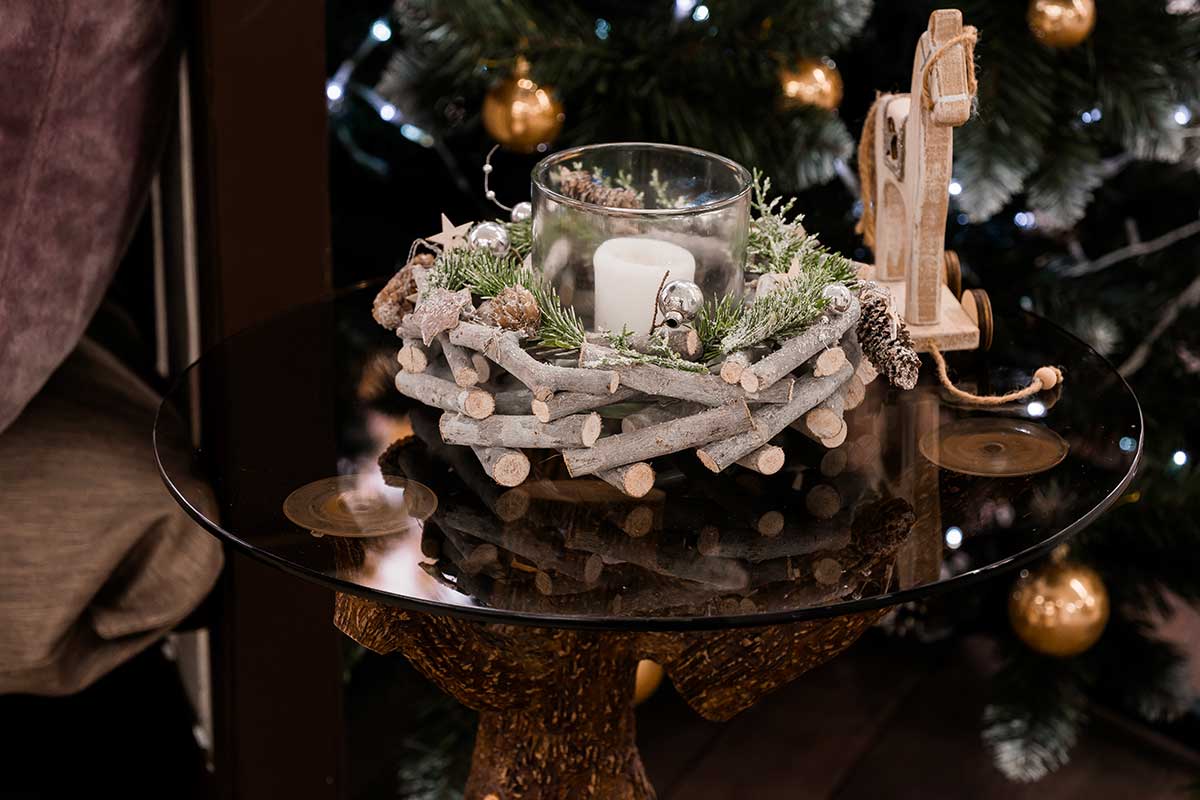 Centrotavola con rametti di legno e candele in barattolo